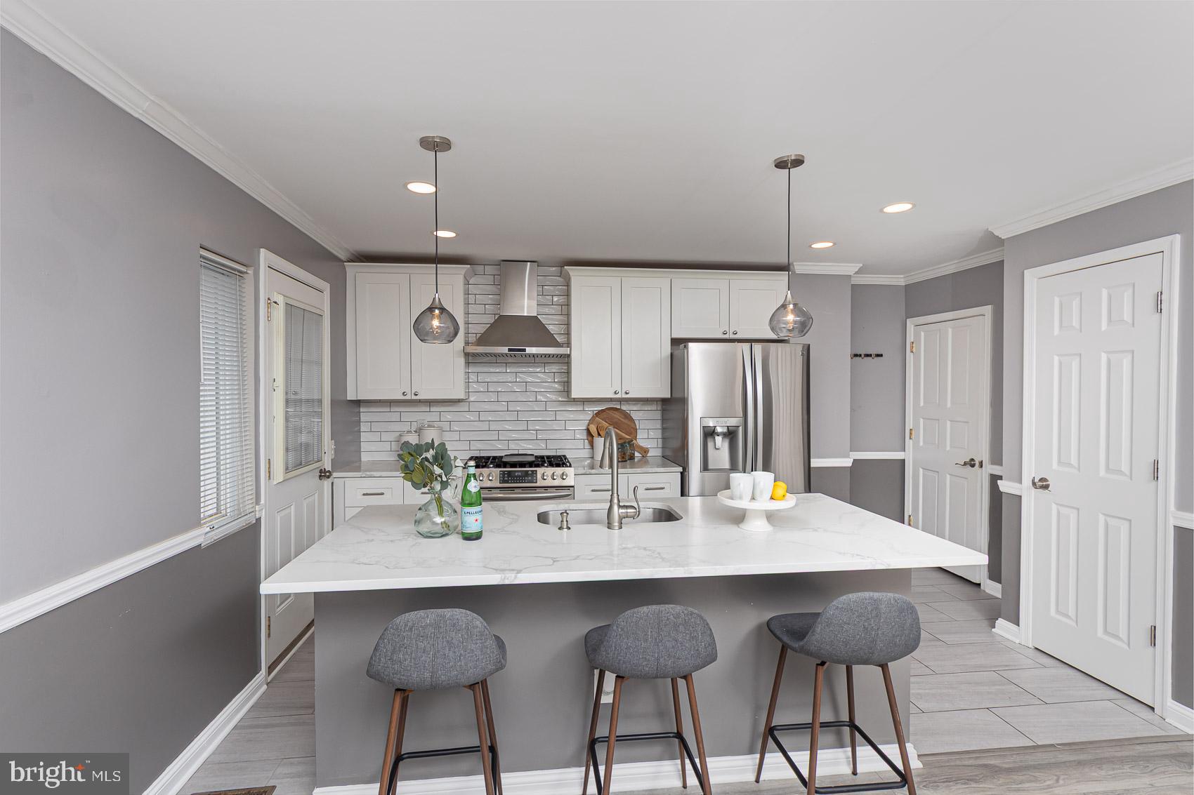 1809 Northbourne Road Baltimore, MD 21239 - Photo 18 of 43 a kitchen with stainless steel appliances a dining table chairs and cabinets