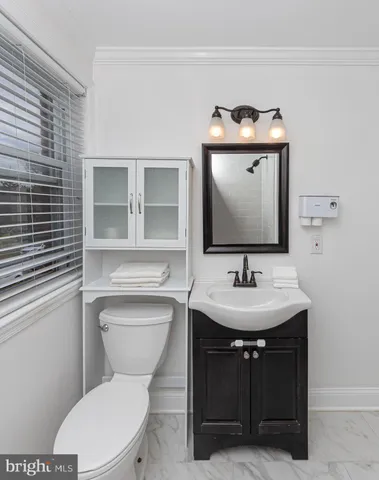 a bathroom with a toilet sink and mirror