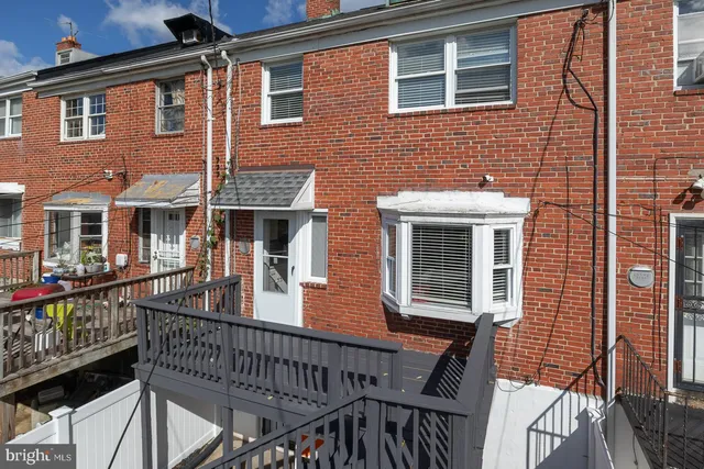 a view of a house with a deck and furniture