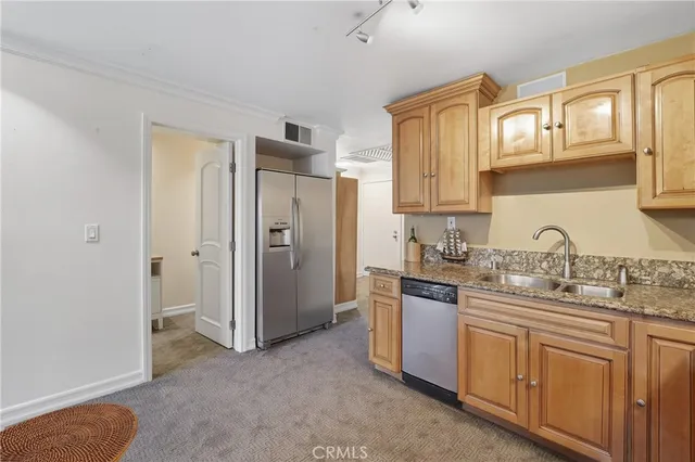 a kitchen with stainless steel appliances granite countertop a refrigerator and a sink