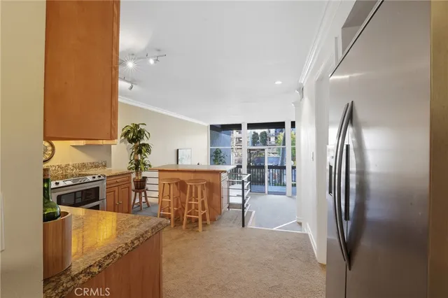 an open kitchen with refrigerator stove and kitchen island