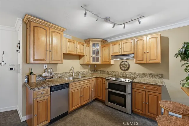 a kitchen with stainless steel appliances granite countertop a sink stove and cabinets