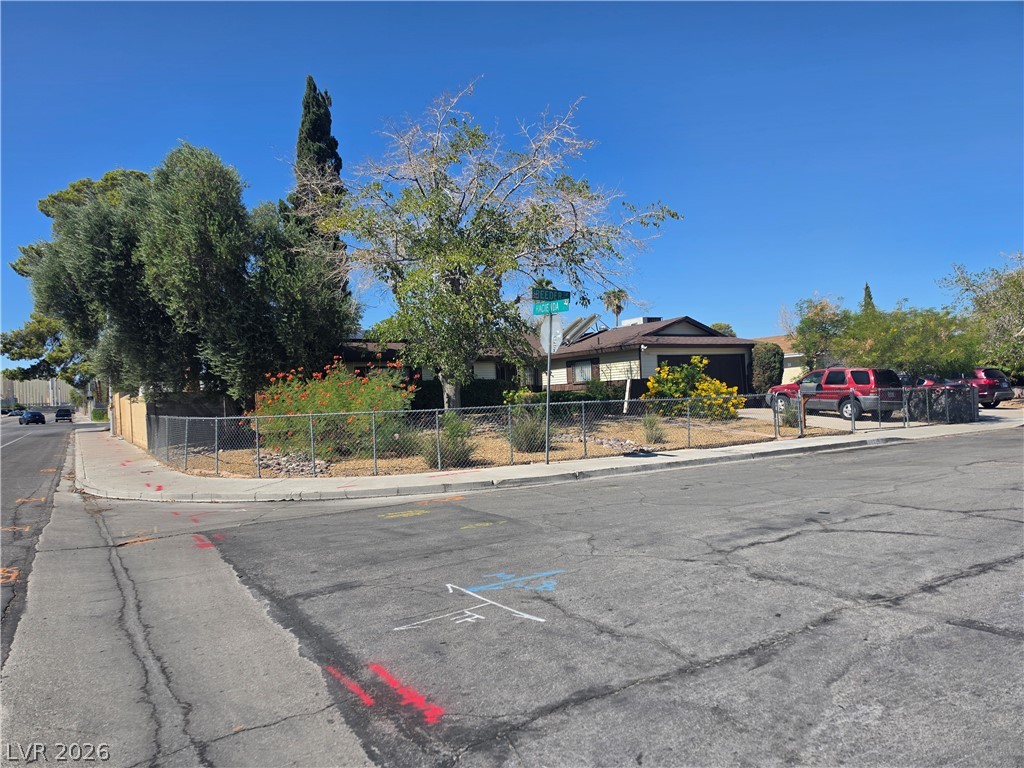 5289 Reeder Circle Las Vegas, NV 89119 - Photo 3 of 40 A prominent corner lot home displays established landscaping behind chain link fencing.