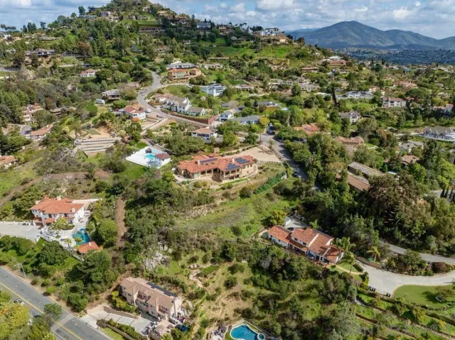 an aerial view of residential house with outdoor space and trees all around