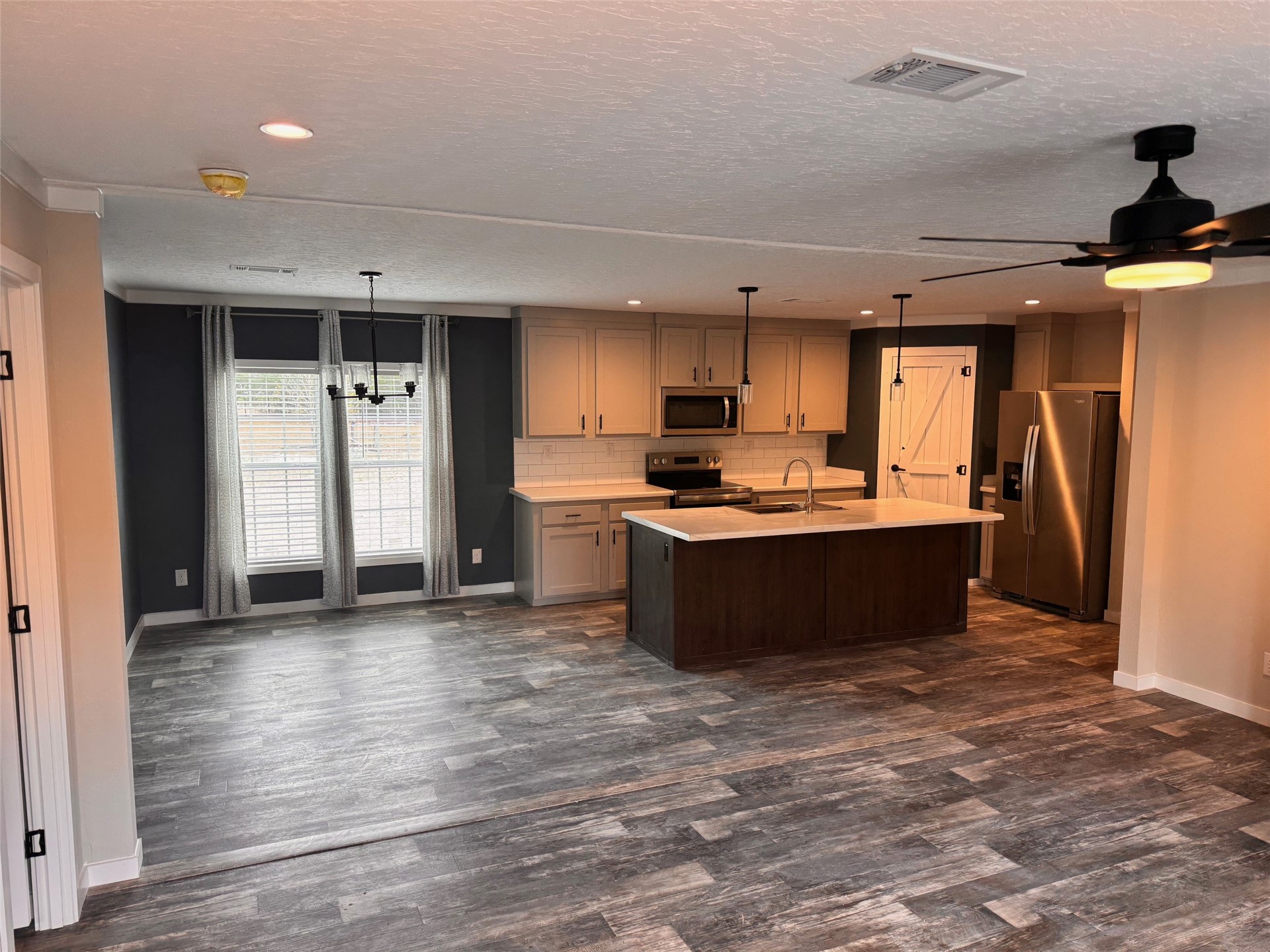 273535 Murrhee Road Hilliard, FL 32046 - Photo 10 of 25 a kitchen with stainless steel appliances kitchen island granite countertop a refrigerator and a stove top oven