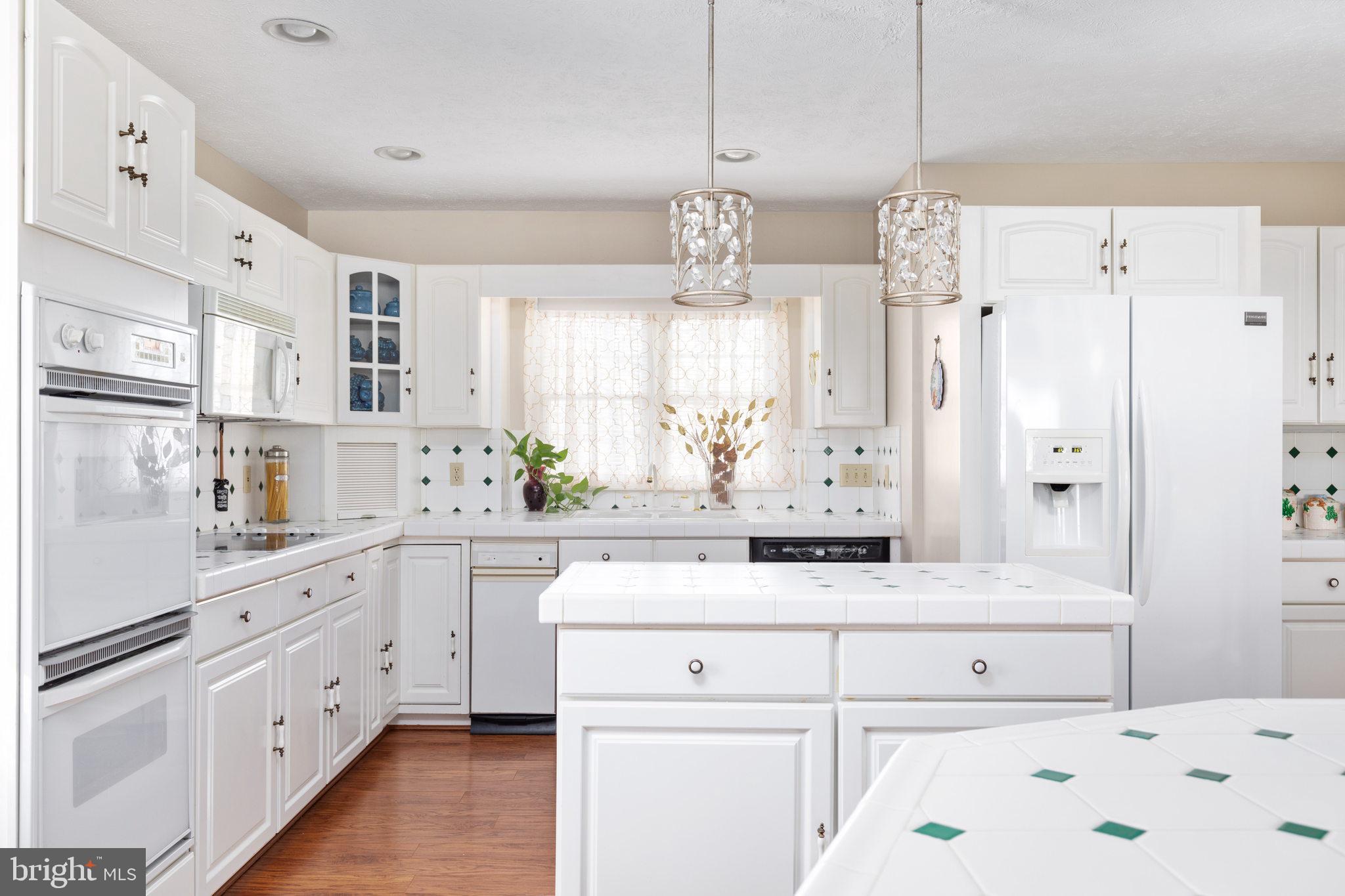 317 Anderson Road Basye, VA 22842 - Photo 5 of 51 a kitchen with kitchen island white cabinets and white appliances