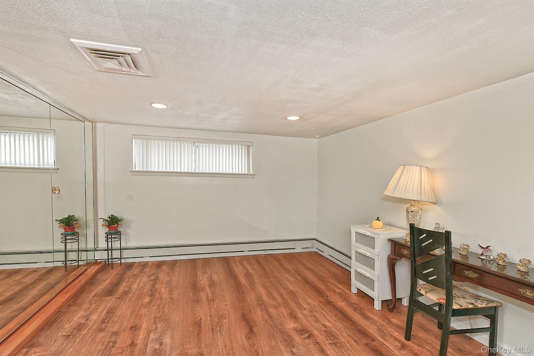 105 Roxton Road Plainview, NY 11803 - Photo 21 of 28 a view of a room with wooden floor lounge chair and windows