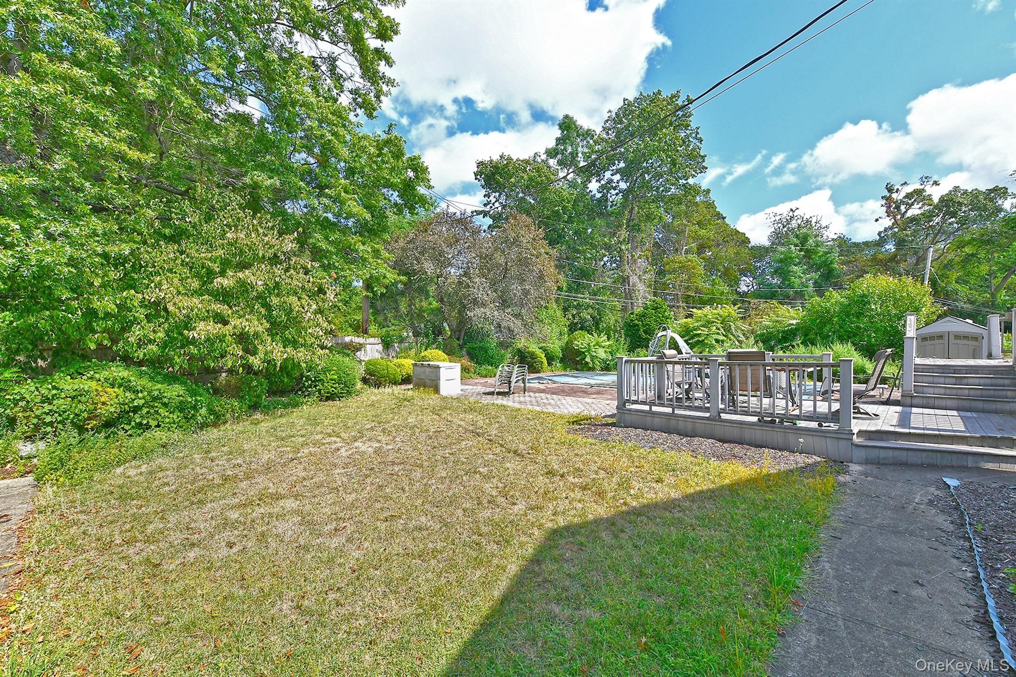 105 Roxton Road Plainview, NY 11803 - Photo 25 of 28 a view of a swimming pool with a patio and garden