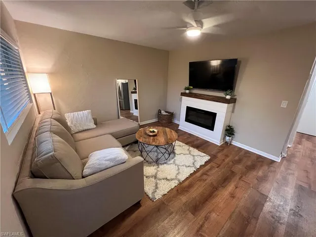 a living room with furniture a fireplace and a flat screen tv