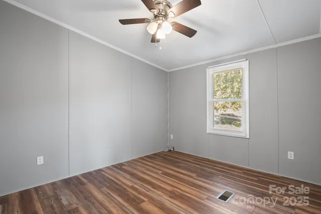a view of empty room with window and ceiling fan