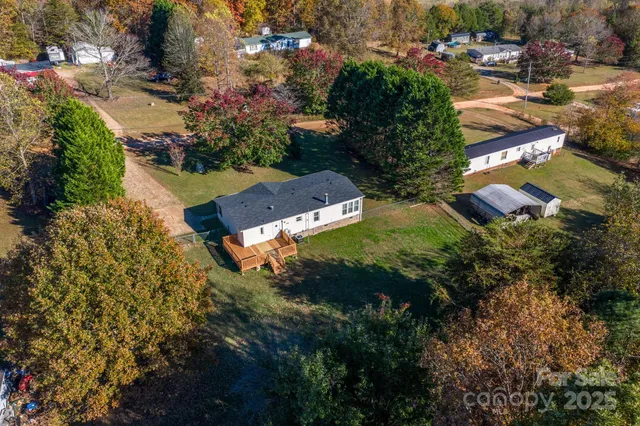 an aerial view of residential house with outdoor space and trees all around