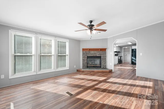 a view of an empty room with a fireplace and a window