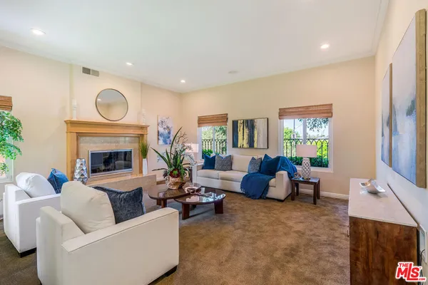 a living room with furniture a fireplace and a large window