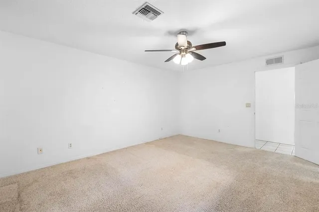 an empty room with a ceiling fan and wooden floor