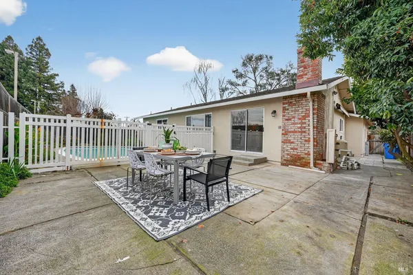 a view of a patio with table and chairs and potted plants with wooden fence