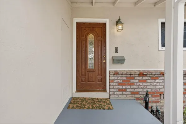 a view of a hallway with wooden floor and a living room