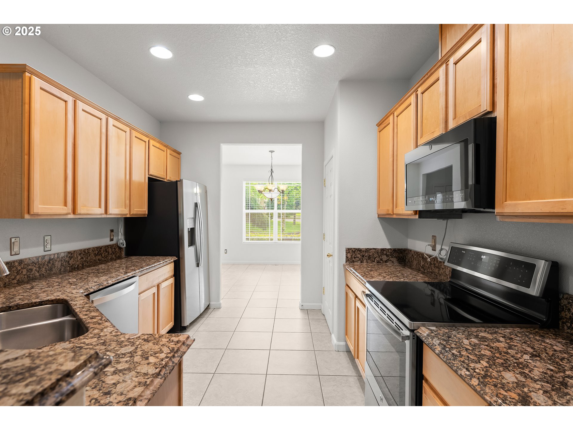 1971 Southwest 19th Terrace Gresham, OR 97080 - Photo 3 of 31 a kitchen with stainless steel appliances granite countertop a stove a sink and a microwave