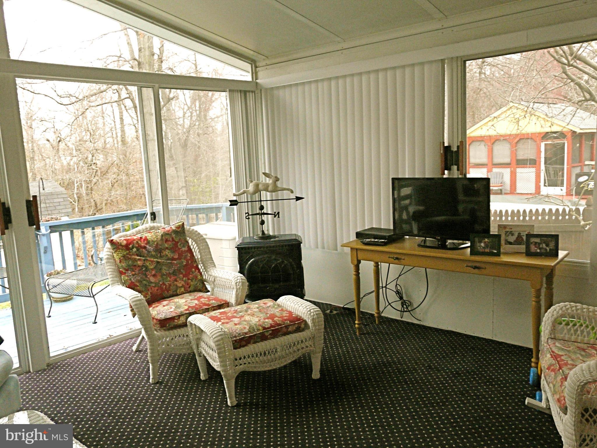 64 Yew Road Baltimore, MD 21221 - Photo 14 of 30 a living room with furniture a flat screen tv and a floor to ceiling window