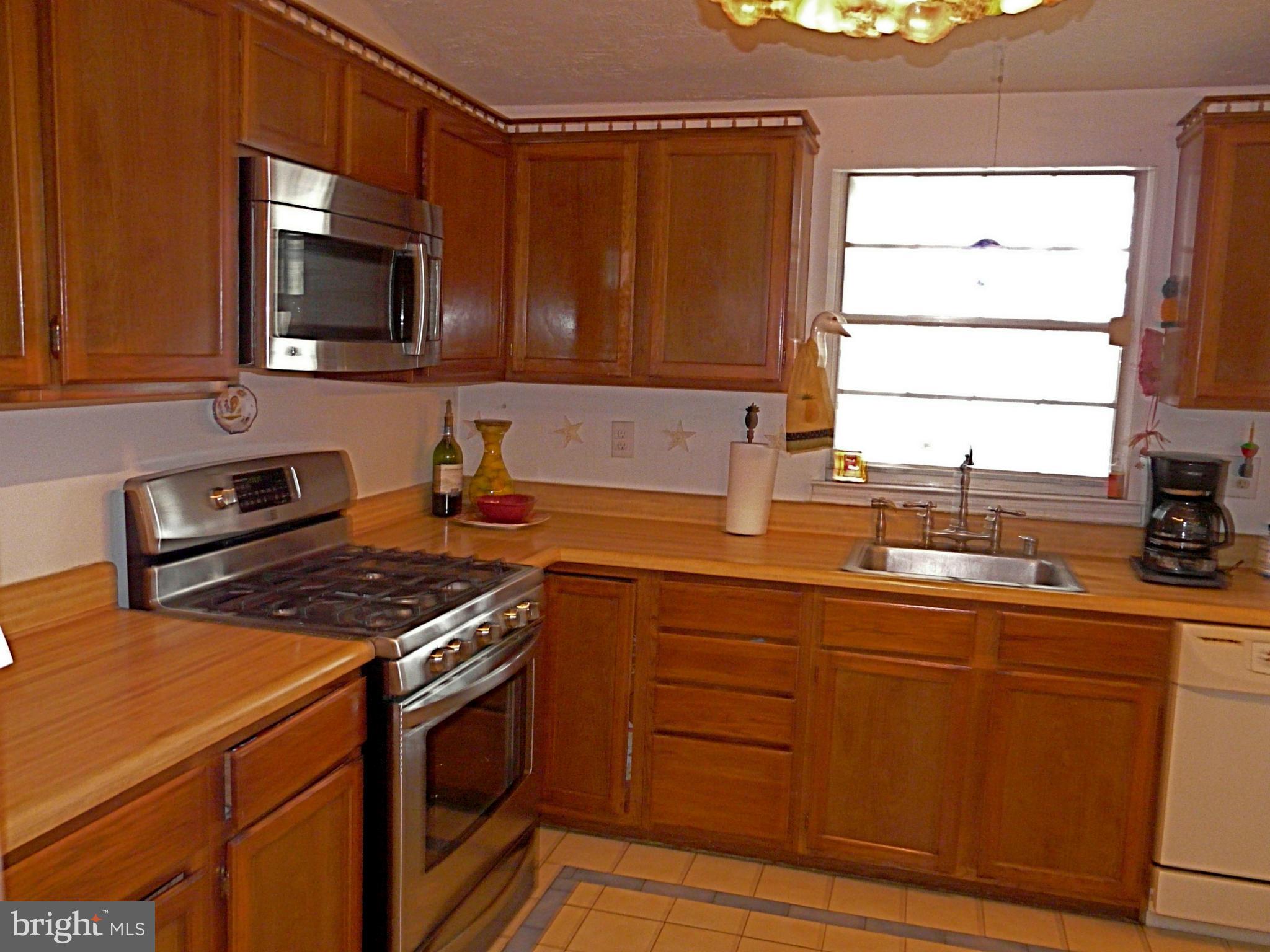 64 Yew Road Baltimore, MD 21221 - Photo 19 of 30 a kitchen with stainless steel appliances a stove microwave and sink