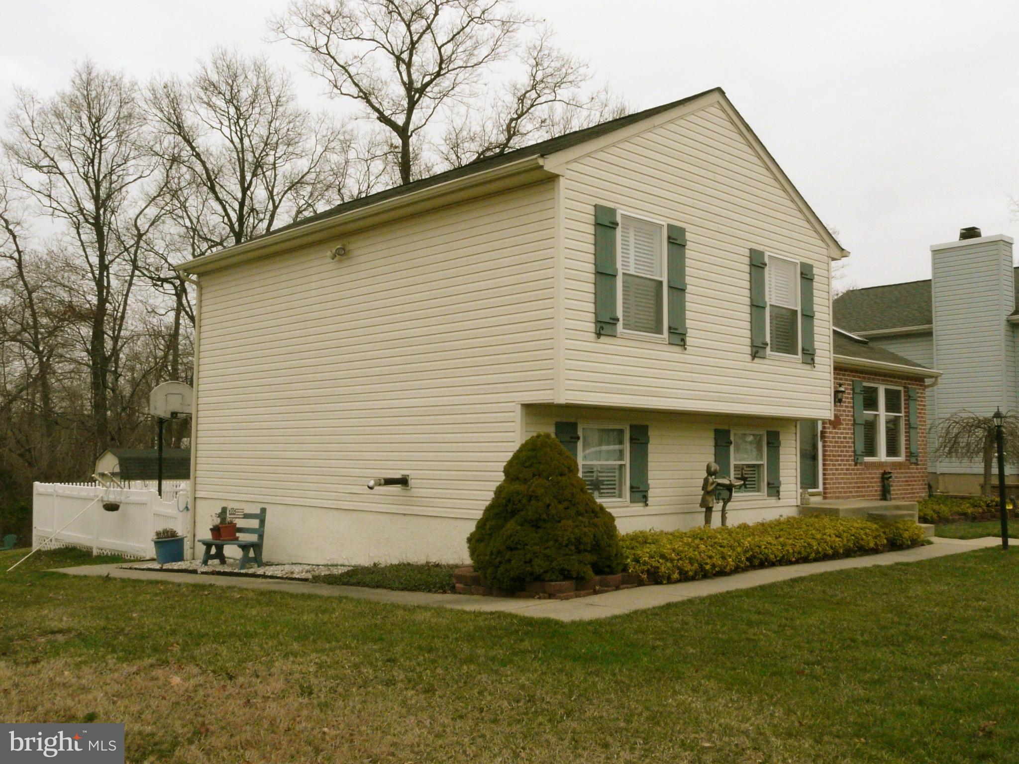 64 Yew Road Baltimore, MD 21221 - Photo 6 of 30 a view of a white house next to a yard with a large tree