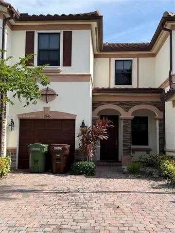 a front view of a house with potted plants