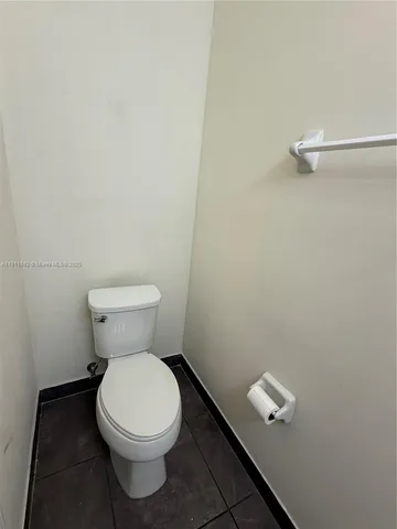 a white toilet sitting next to a white wall