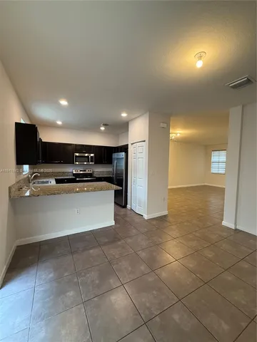 a view of kitchen with stainless steel appliances a refrigerator and a stove top oven