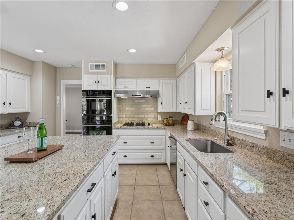 3863 Clayton Road East Fort Worth, TX 76116 - Photo 12 of 39 a kitchen with stainless steel appliances granite countertop a sink stove and cabinets