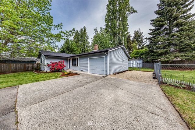 a front view of house with garage and a garden