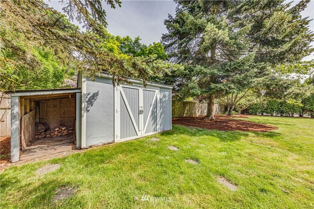 a view of backyard with a barn and large trees