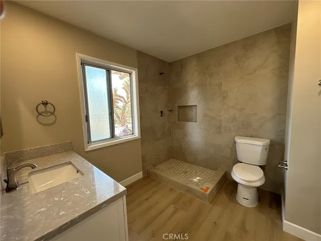 a bathroom with a granite countertop sink toilet and shower
