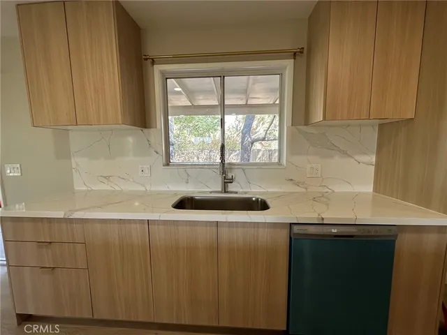a kitchen with a sink a window and cabinets