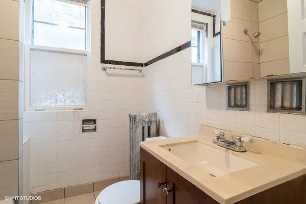 a bathroom with a sink vanity mirror and toilet