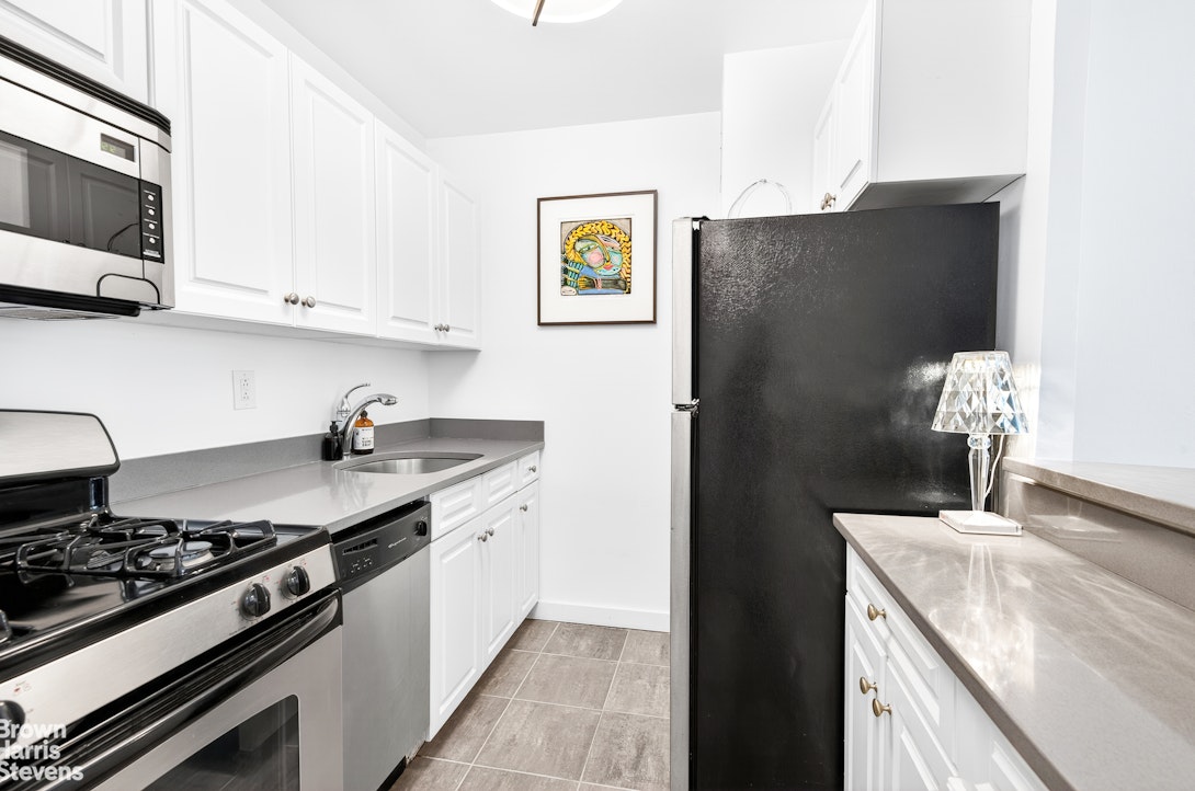 520 East 72nd Street, Unit 3G Manhattan, NY 10021 - Photo 6 of 15 a kitchen with stainless steel appliances granite countertop a refrigerator and a sink
