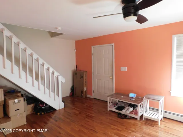 a view of a hallway with wooden floor and staircase