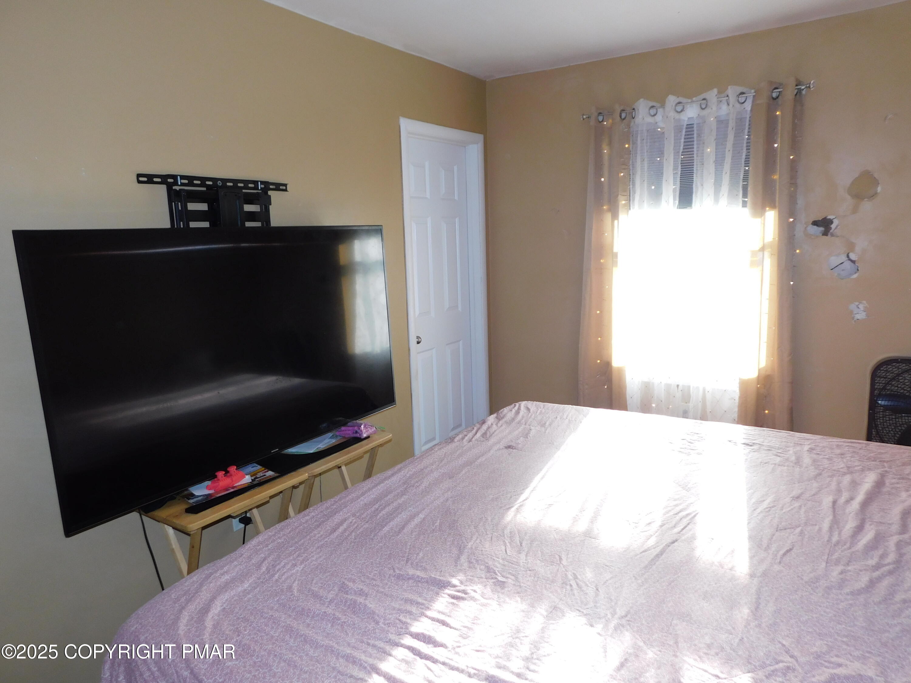 64 North 2nd Street, Unit A Stroudsburg, PA 18360 - Photo 6 of 12 a bedroom with a bed and a flat screen tv