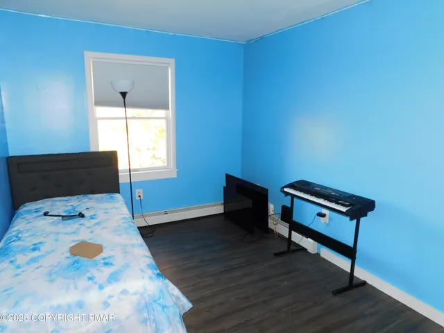 a view of an empty room with wooden floor and cabinets