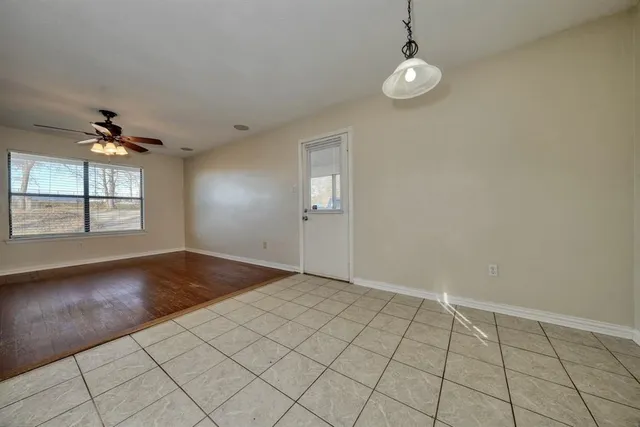 an empty room with windows and ceiling fan