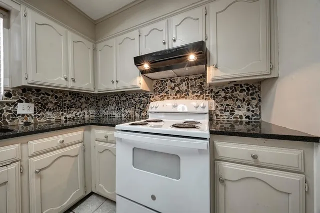 a kitchen with white cabinets and appliances