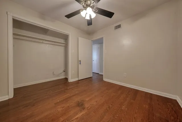 a view of an empty room and chandelier fan