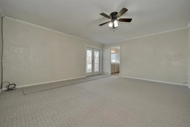 an empty room with ceiling fan and window