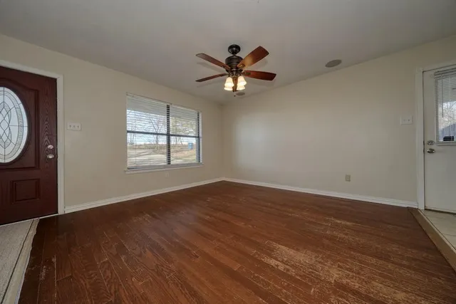 wooden floor in an empty room with a window