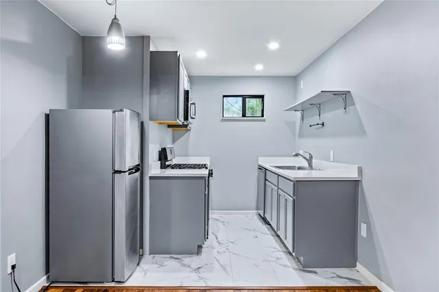 a kitchen with a refrigerator sink and cabinets