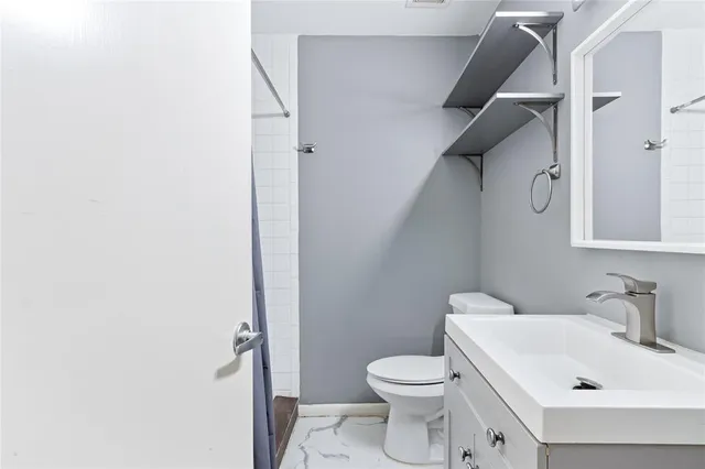 a white toilet sitting next to a bathroom sink
