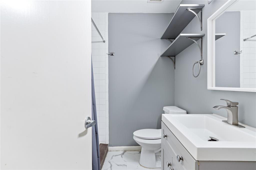 1804 Gould Street, Unit 9 Dallas, TX 75215 - Photo 8 of 12 a white toilet sitting next to a bathroom sink