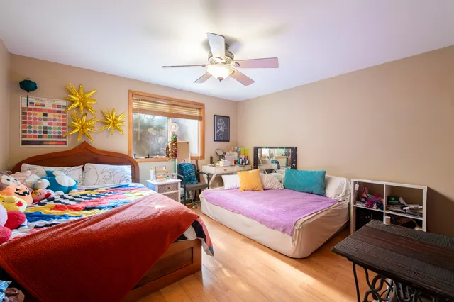 a bedroom with two beds and a desk