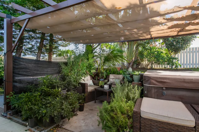 a backyard of a house with a garden and outdoor seating