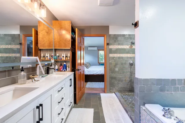 a bathroom with a double vanity sink a toilet and a shower