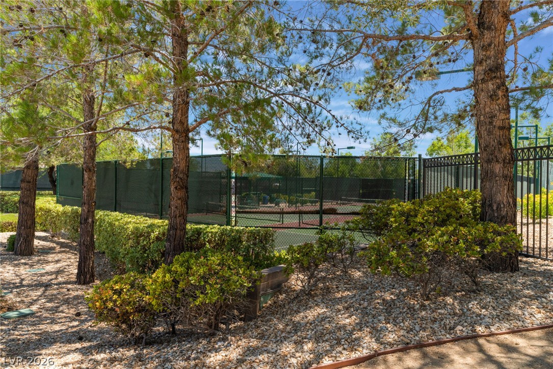5389 Progresso Street Las Vegas, NV 89135 - Photo 40 of 41 Green landscaping and mature trees surround a well-maintained community tennis court.
