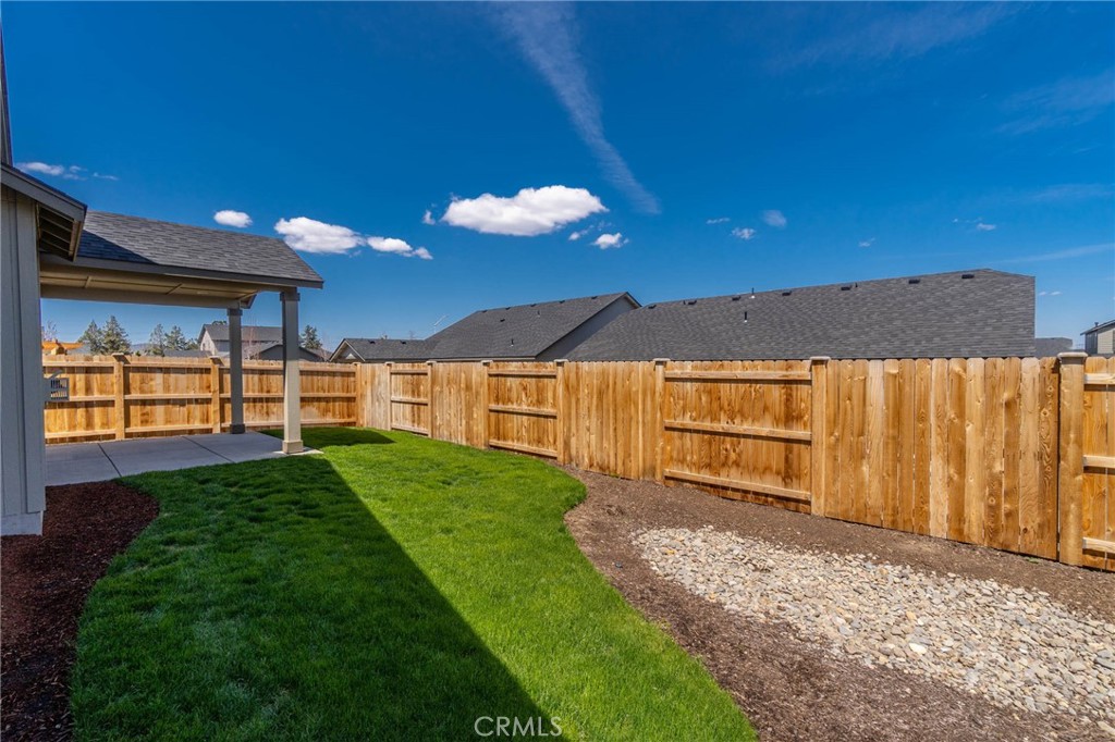 3667 Southwest Pumice Stone Avenue Redmond, OR 97756 - Photo 4 of 13 a view of a backyard with large trees and wooden fence